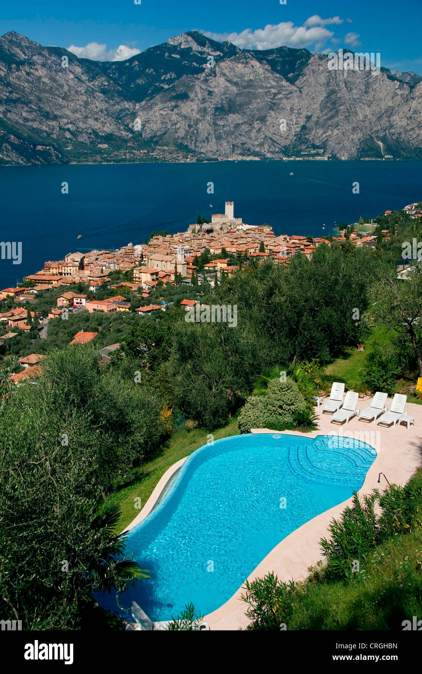 Vista sul villaggio, Castello Scaligero e del Lago di Garda, con una piscina in primo piano, Italia, Veneto, Malcesine Foto Stock