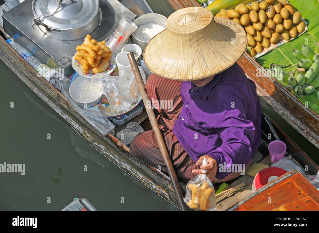 Mercato galleggiante, venditore che offre uno snack, Thailandia, Damnoen Saduak Foto Stock