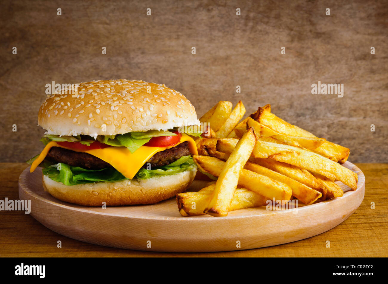 Il fast food hamburger e patatine fritte su un piatto di legno Foto Stock