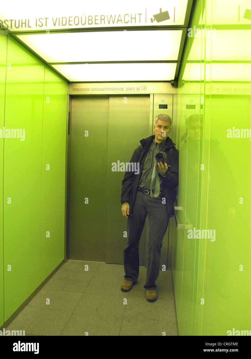 Uomo in un ascensore con fotocamera, in Germania, in Renania settentrionale-Vestfalia, Deutz, Koeln Foto Stock