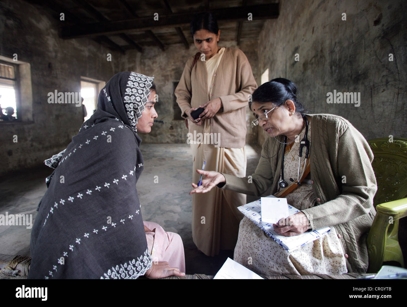 Medico Volontario (destra) esamina malati abitanti di un villaggio in India senza alcun costo/royalty Foto Stock