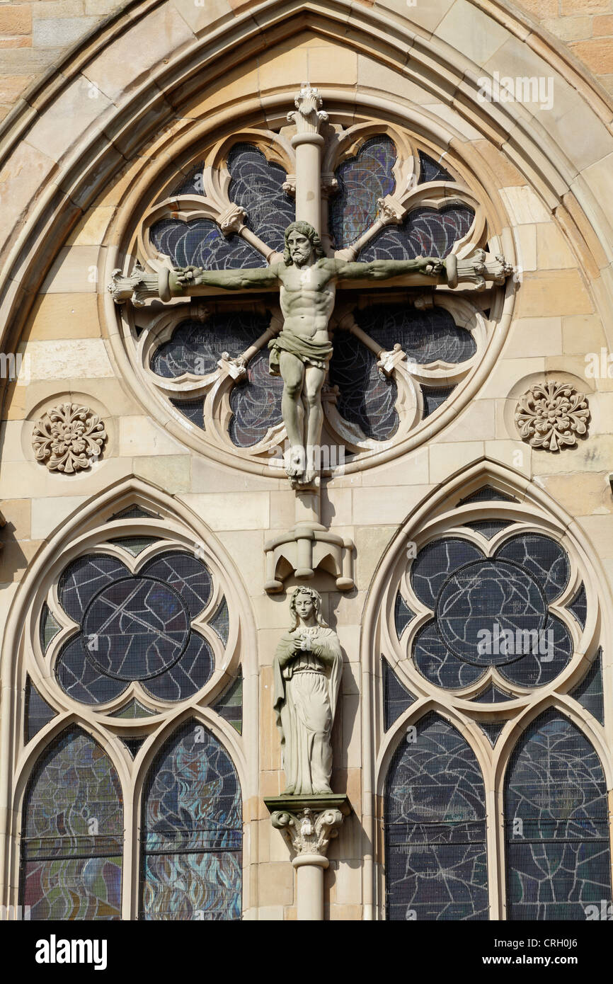 Scultura in pietra di Gesù Cristo sulla croce sulla façade della chiesa cattolica romana di San Mungo, Parson Street, Townhead, Glasgow, Scozia, REGNO UNITO Foto Stock