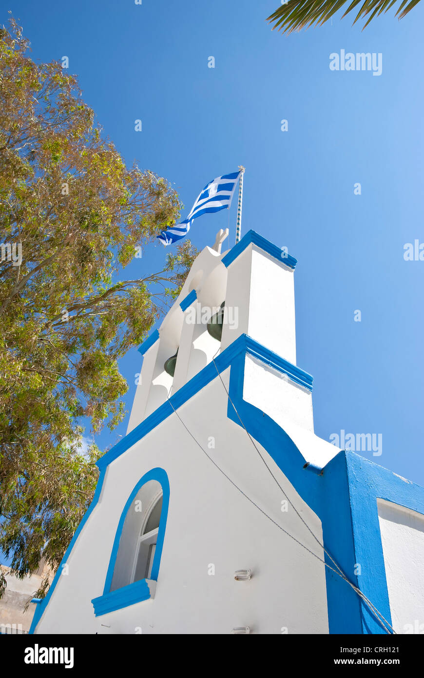 Un blu e bianco greco-ortodossi la cappella e la Torre Campanaria con la bandiera greca battenti Foto Stock