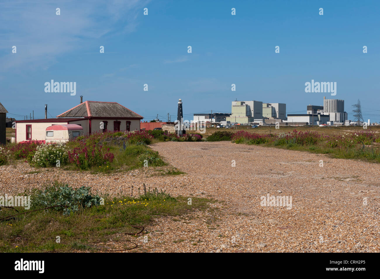 Casa sulla spiaggia atDungeness, Kent, Regno Unito con il faro e il power station in background Foto Stock