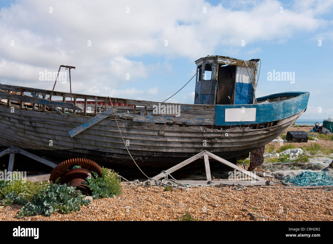 Fatiscente barca da pesca sulla spiaggia di ciottoli a Dungeness, Kent, Regno Unito Foto Stock