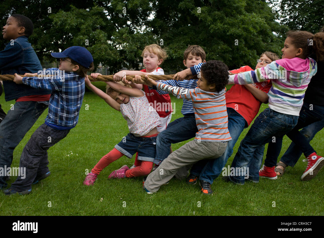 Bambini locali heave-ho su una corda di grandi dimensioni per il migliore dei tre tug o i giochi di guerra durante una comunità park festival. Foto Stock