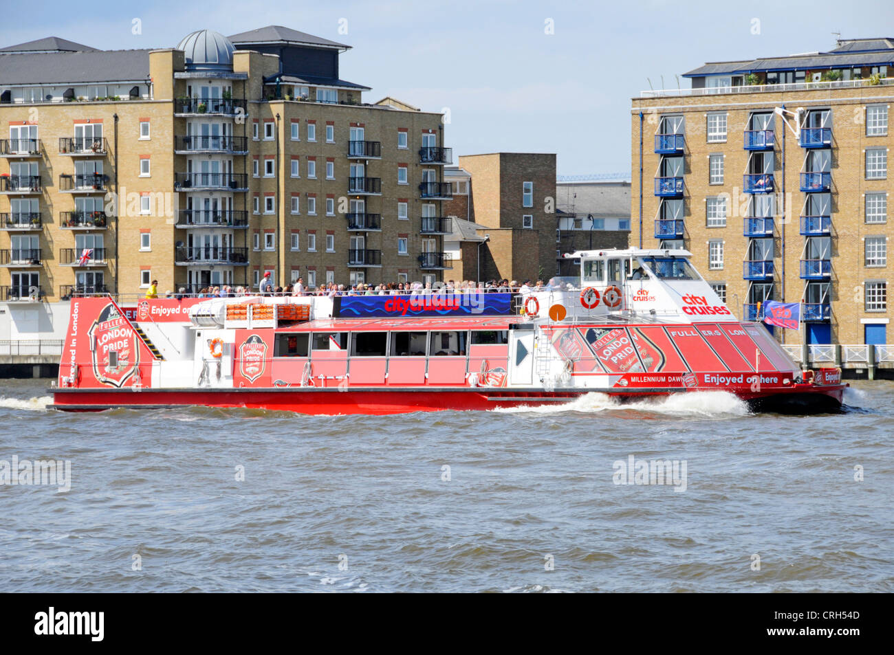City Cruises tour in barca con gualchiere London Pride pubblicità passando moderni blocchi di appartamenti vicino a Canary Wharf sul Fiume Tamigi Foto Stock