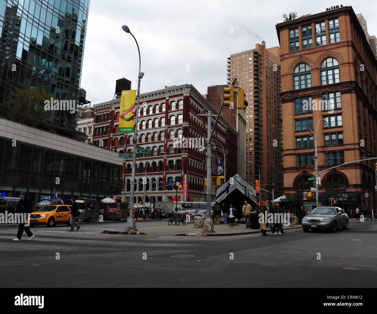 Cielo grigio visualizzare red brick apartments, Cubo scultura equilibratura di un angolo, isola di traffico, il Luogo di Astor, East Village, New York Foto Stock