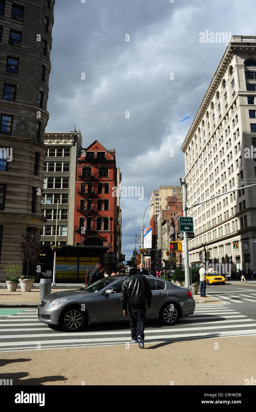 Sunny nuvole grigie ritratto, verso West 23rd Street, afro-americano di uomo attraversando Broadway a East 23rd Street, New York Foto Stock