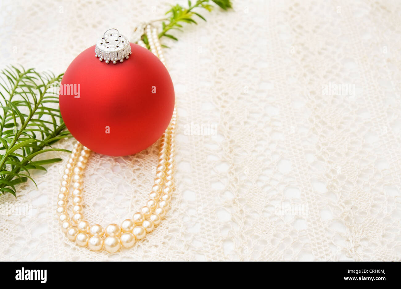 Vintage Natale biglietto di auguri con il tradizionale rosso ninnolo e vecchi pearls su pizzi fatti a mano. Foto Stock