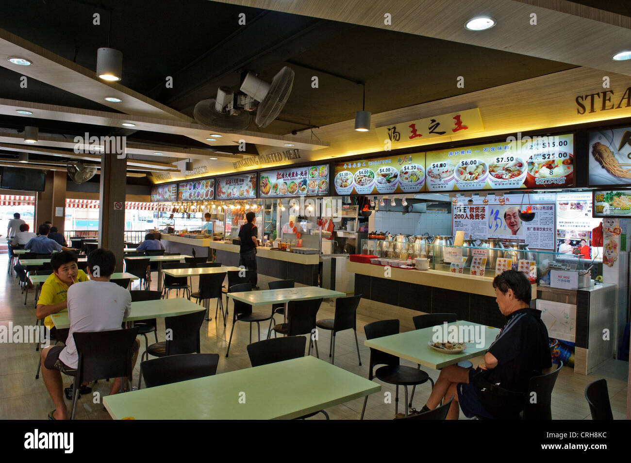 Diners a un cibo tradizionale corte presso un centro Hawker, Singapore. Foto Stock