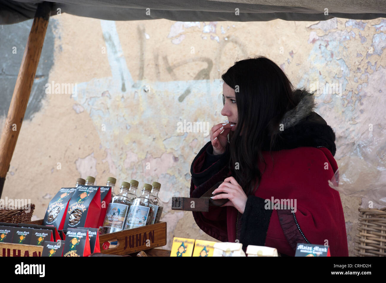 Una bella donna vendita di Olde Hansa speziato le mandorle in una fase di stallo a Tallinn, Estonia, Stati Baltici Foto Stock