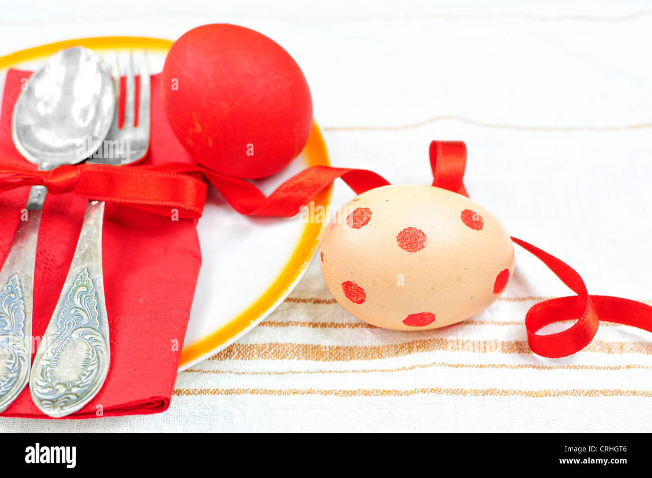 Cena di Pasqua o il pranzo insieme - cucchiaio e forchetta nella piastra con rosso uova colorate Foto Stock