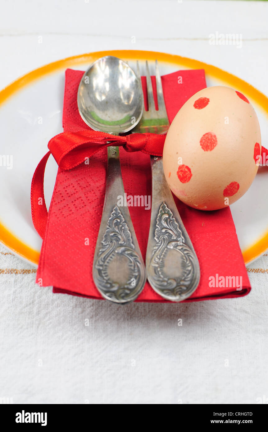 Cena di Pasqua o il pranzo insieme - cucchiaio e forchetta inplate con rosso uova colorate Foto Stock
