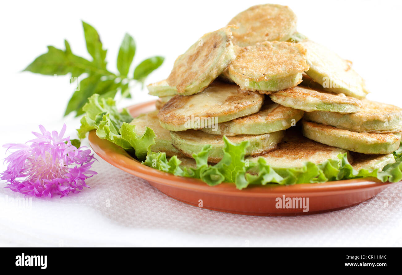 Zucchine fritte su un piatto di marrone. Zucchine fritte in pastella di uovo. Foto Stock