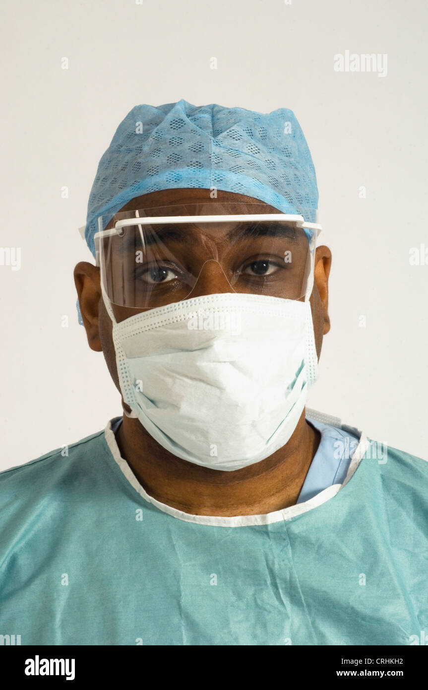 Chirurgo ospedaliero indossando igiene hat, maschere igieniche e di plastica visiera protettiva. Foto Stock