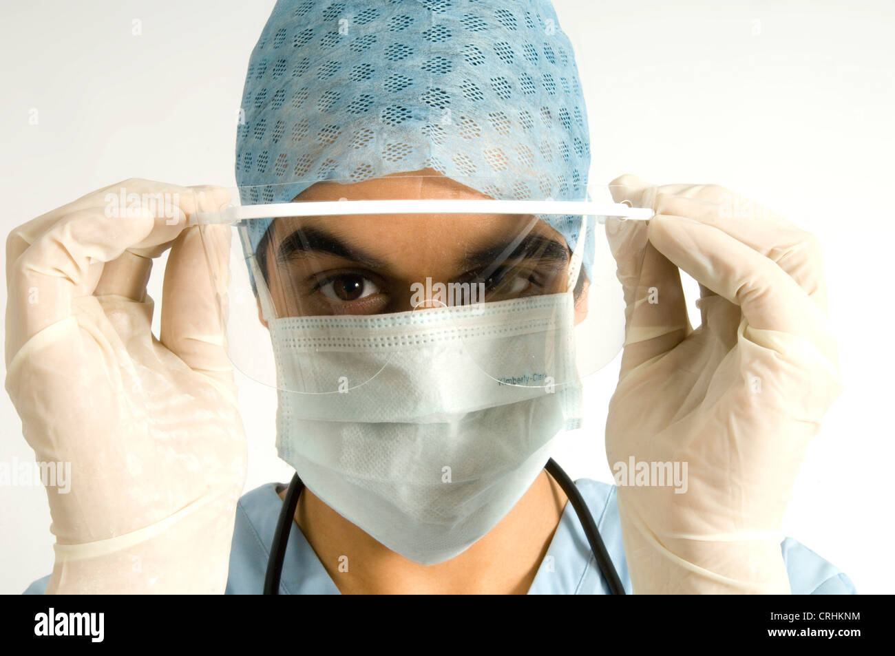 Close-up del volto di un chirurgo di indossare una visiera chirurgico, mascherina igienica, igiene hat. Foto Stock