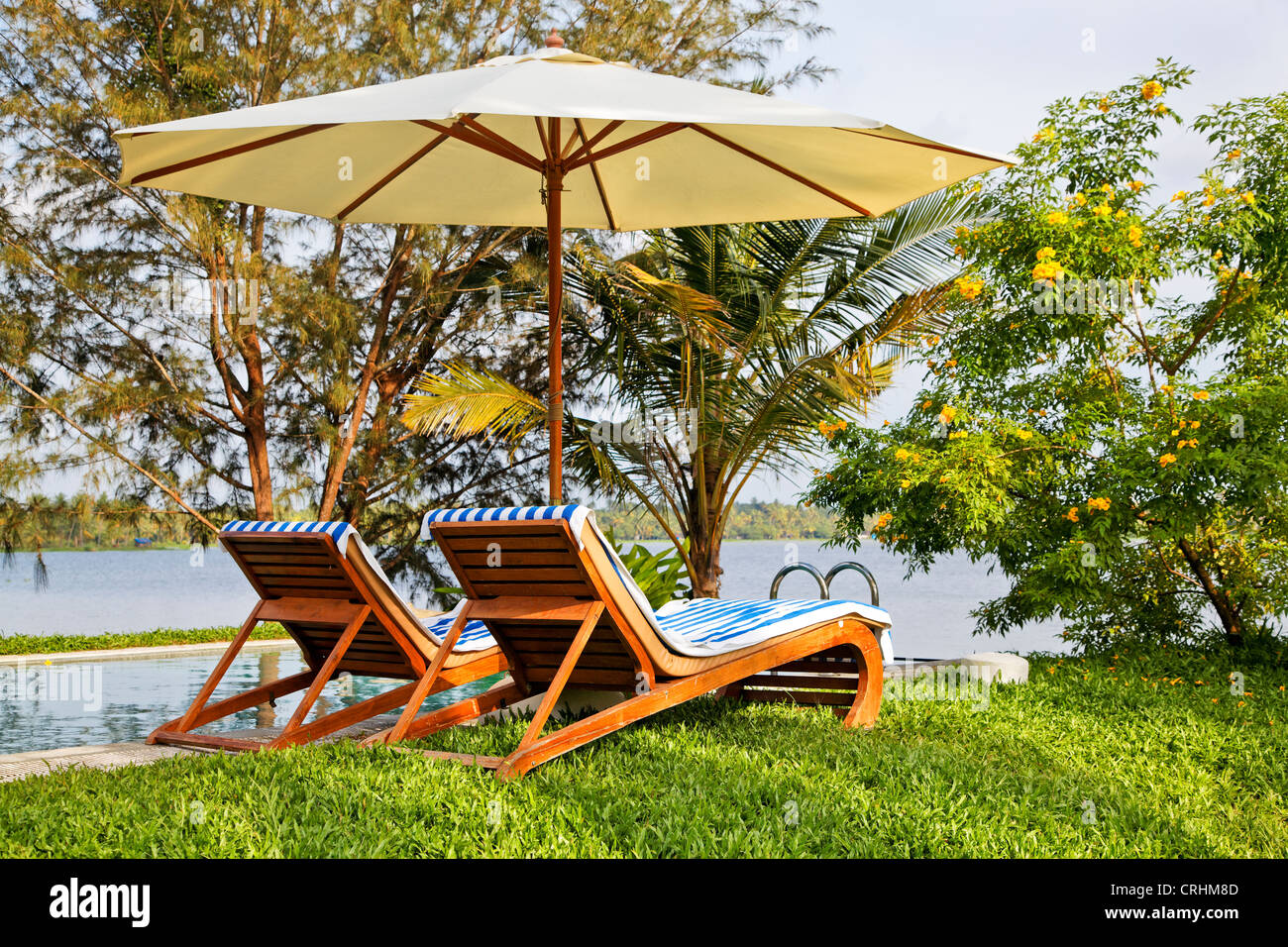 Paesaggio di verde laguna piscina infinity con matura landcsaped maturi giardini con vista lago Foto Stock
