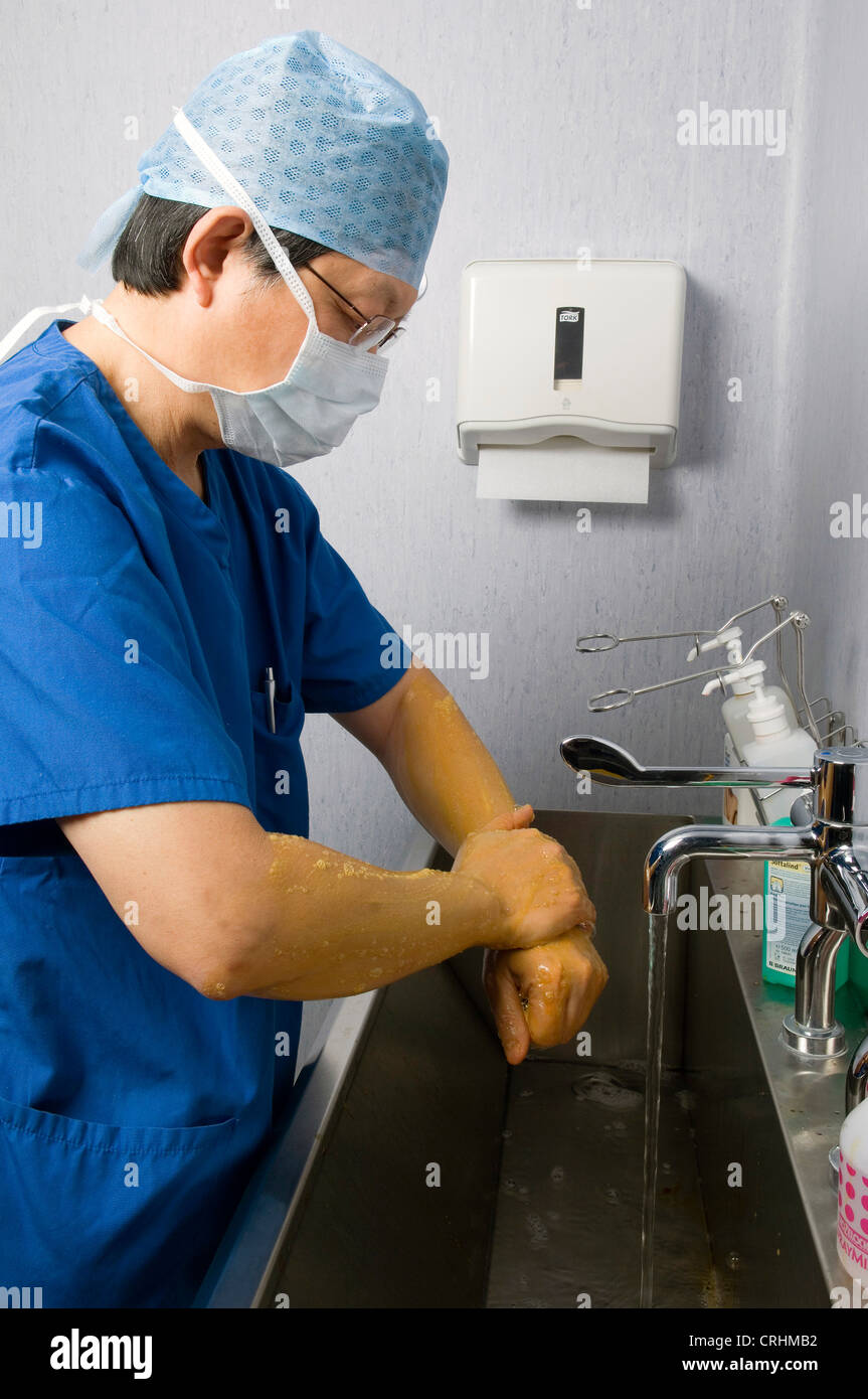 Un medico frega le mani come parte della procedura prima e dopo la chirurgia. Foto Stock
