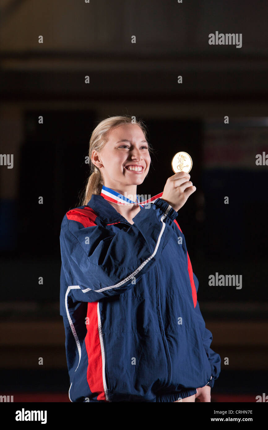 Sorridente atleta femminile tenendo la medaglia d'oro Foto Stock