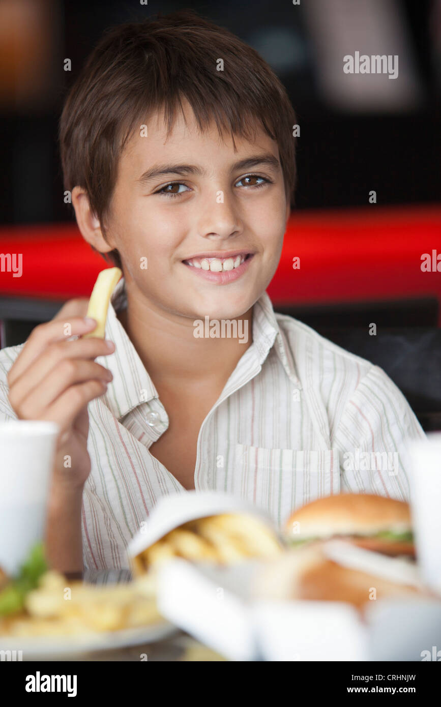 Ragazzo di mangiare fast food, ritratto Foto Stock