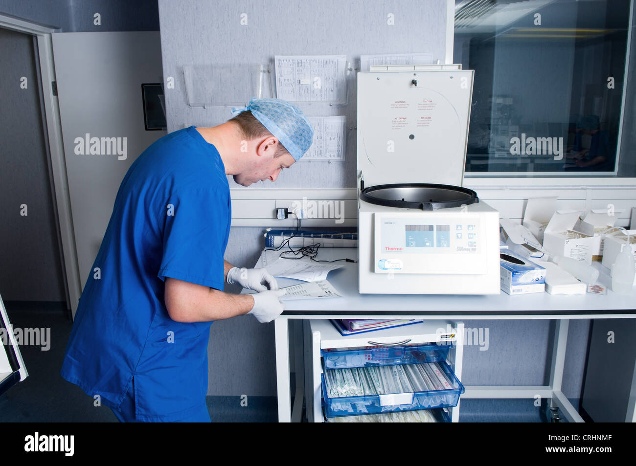 Un medico controlla il paziente lavoro di carta per identificare la fase in cui i campioni sono stati trattati a. Foto Stock