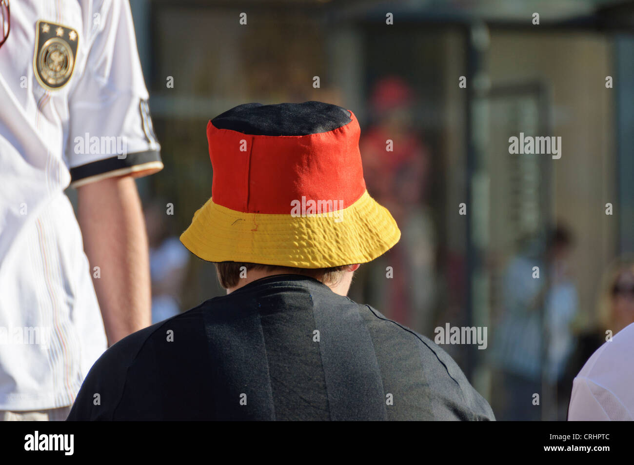 Calcio Maschile appassionato di calcio con divertenti hat in bandiera tedesca i colori nazionali tedeschi del Team t-shirt dress nero oro rosso Foto Stock