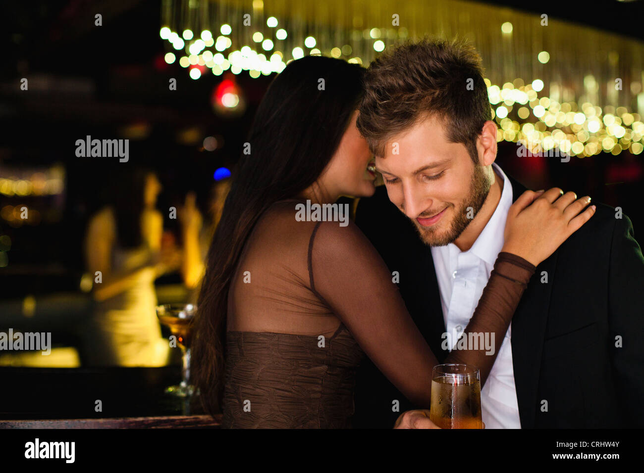 Coppia sorridente whispering presso il bar Foto Stock