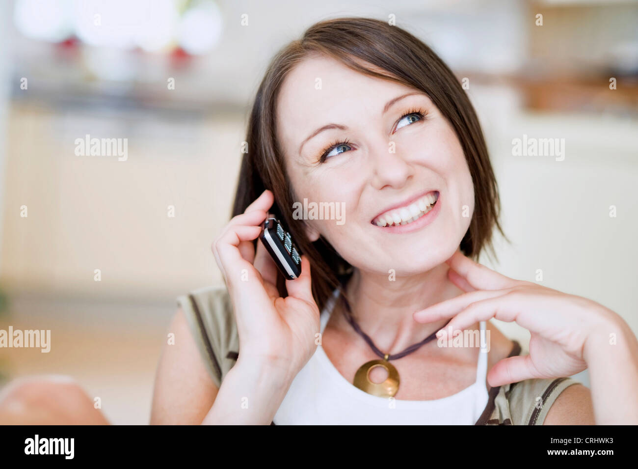 Giovane donna di casa con il telefono cellulare Foto Stock