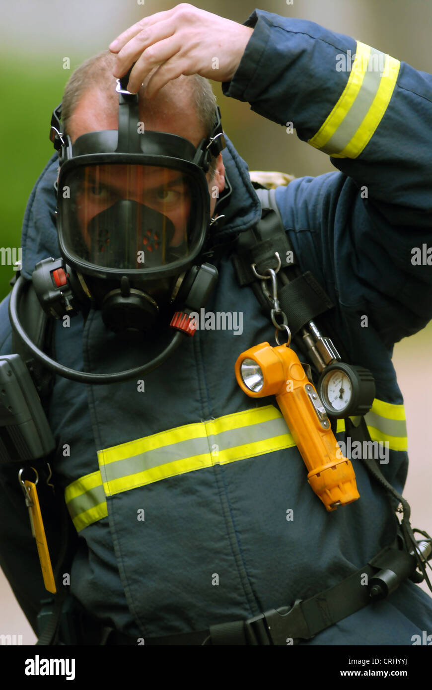 Un vigile del fuoco mette sul suo apparato di respirazione. Foto Stock
