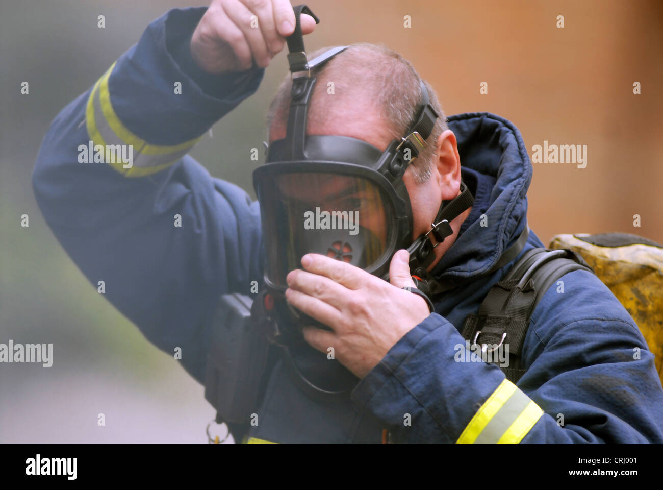 Un vigile del fuoco mette sul suo apparato di respirazione. Foto Stock