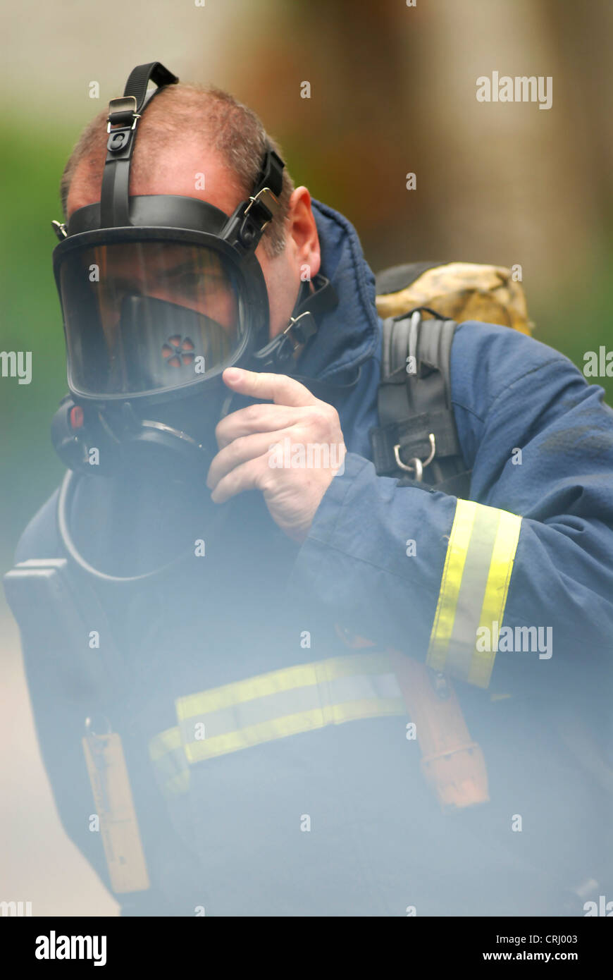 Un vigile del fuoco mette sul suo apparato di respirazione. Foto Stock
