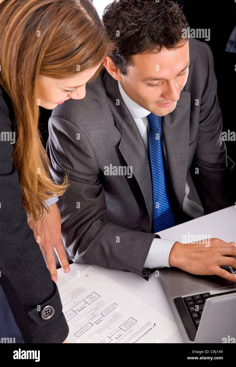 I giovani uomini di affari che circonda un laptop Foto Stock