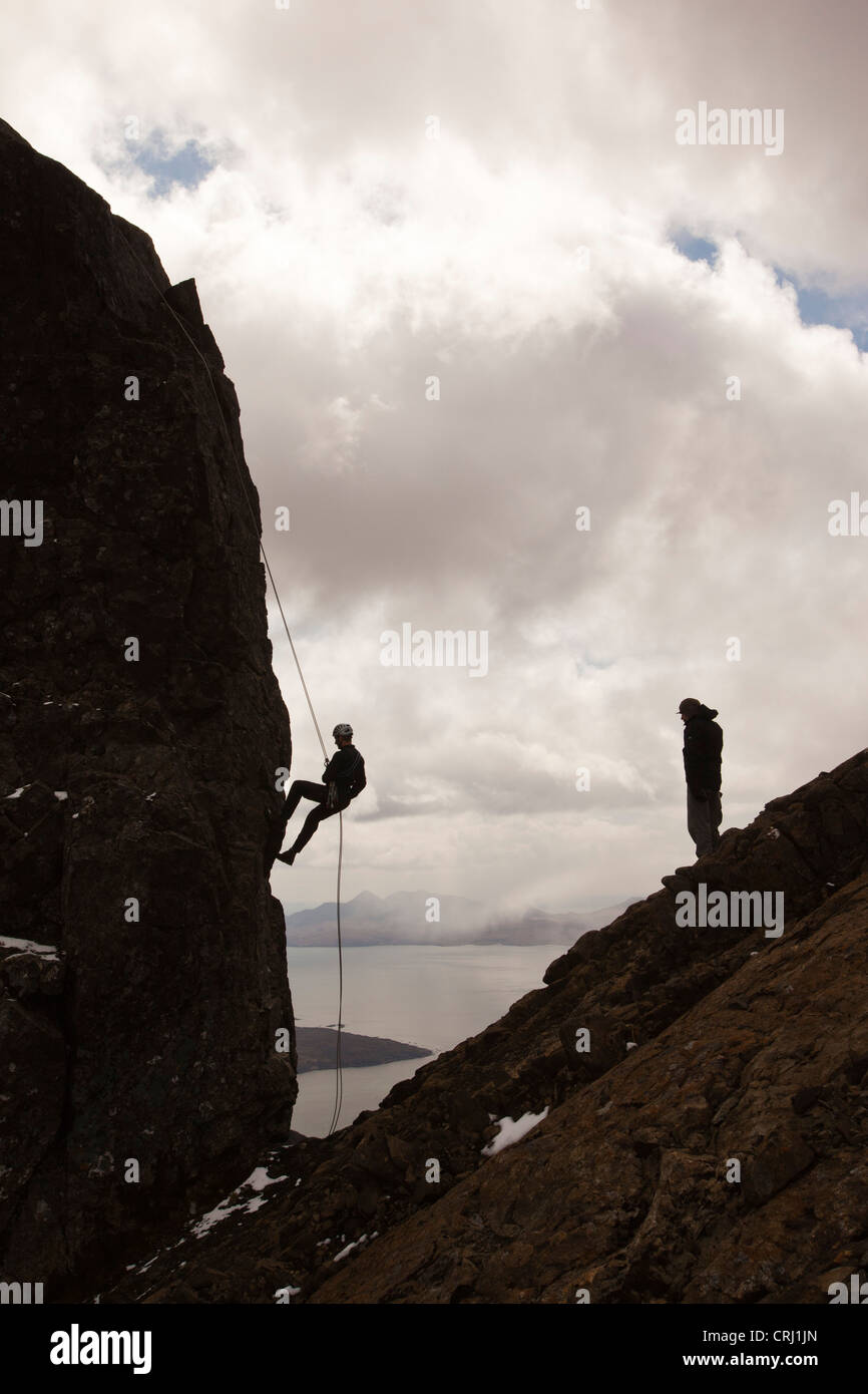 Gli alpinisti la discesa in corda doppia dalla vetta del pinnacolo inaccessibile sul Sgurr Dearg nelle montagne Cuillin Foto Stock