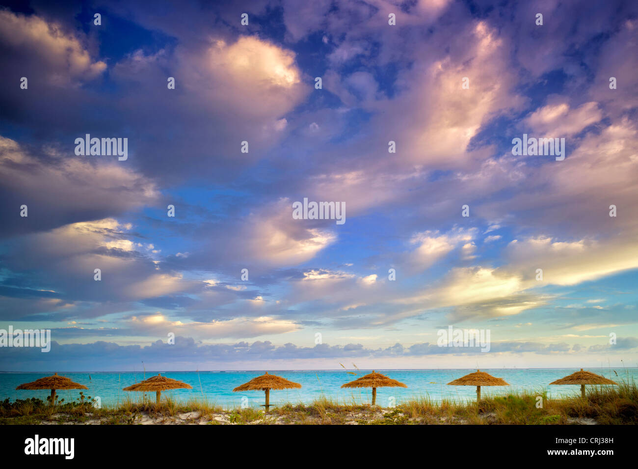 Umbellas Reed e nuvole di sunrise. Isole Turks e Caicos. Providenciales Foto Stock