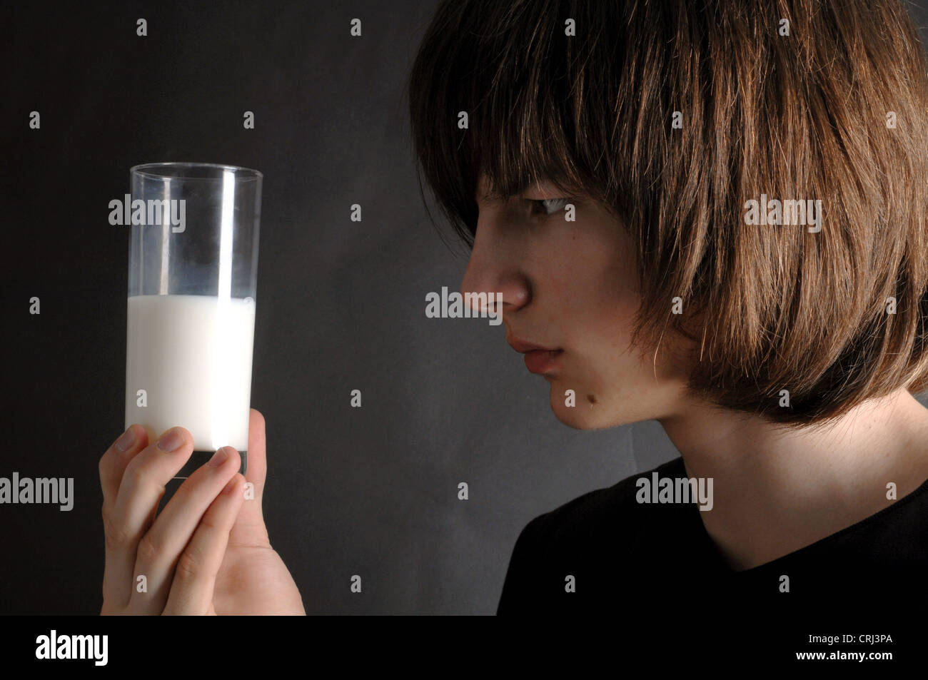 Adolescente di decidere o meno di un bicchiere di latte. Foto Stock