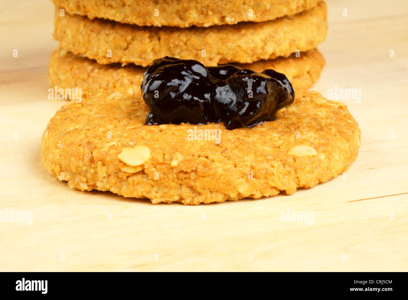 Croccante cereale i biscotti con la marmellata su un sfondo di legno Foto Stock