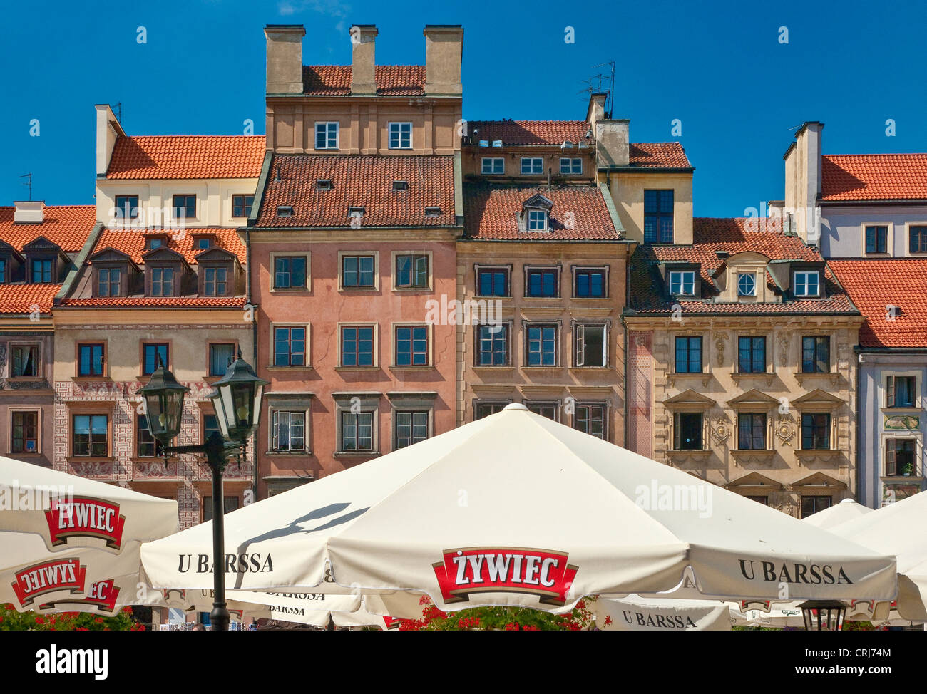 Case borghesi e ombrelloni presso i caffè all'aperto in Piazza del Mercato nella Città Vecchia di Varsavia, Polonia Foto Stock