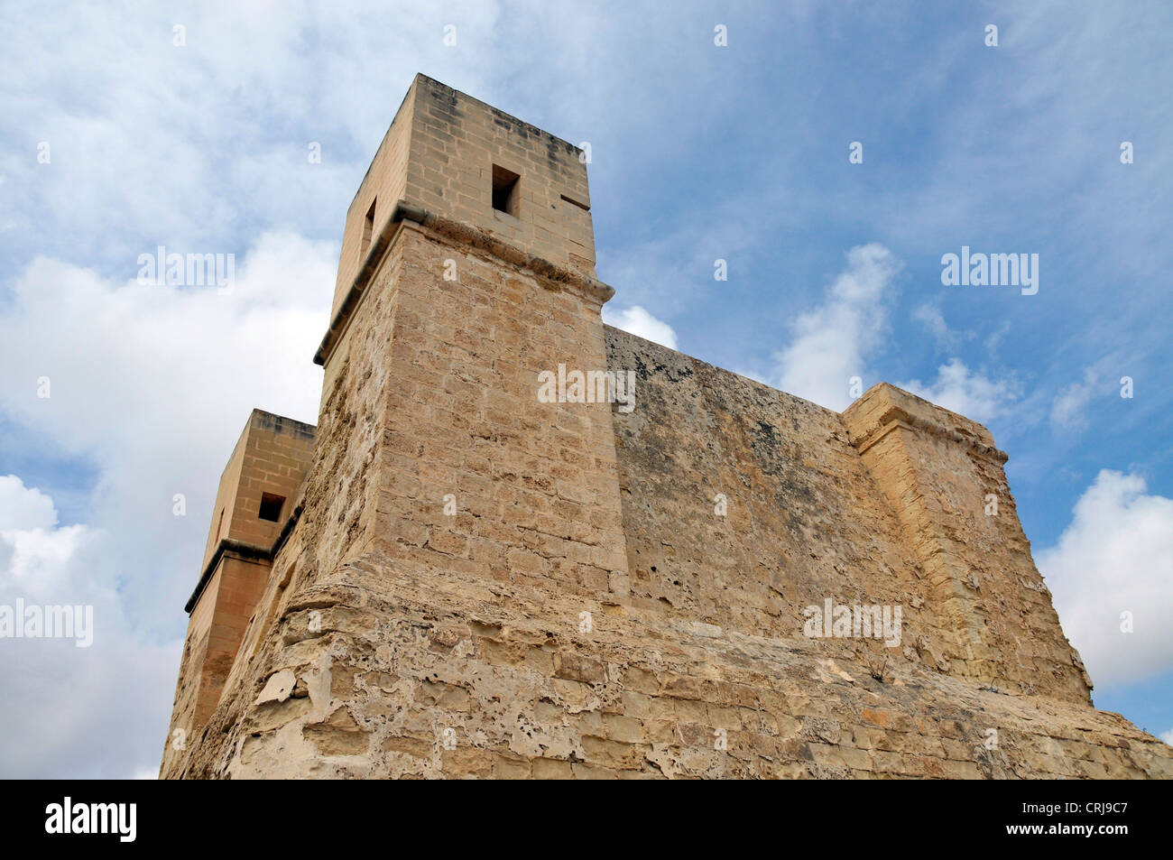 Molto vecchia torre dalla Pauls Bay su Malta con cielo blu e nuvole Foto Stock
