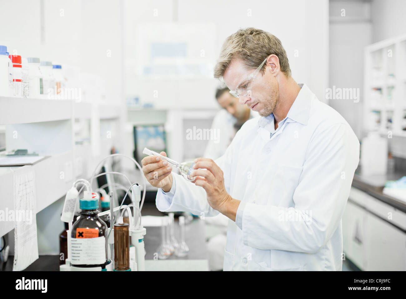 Scienziato liquido di esame in laboratorio Foto Stock