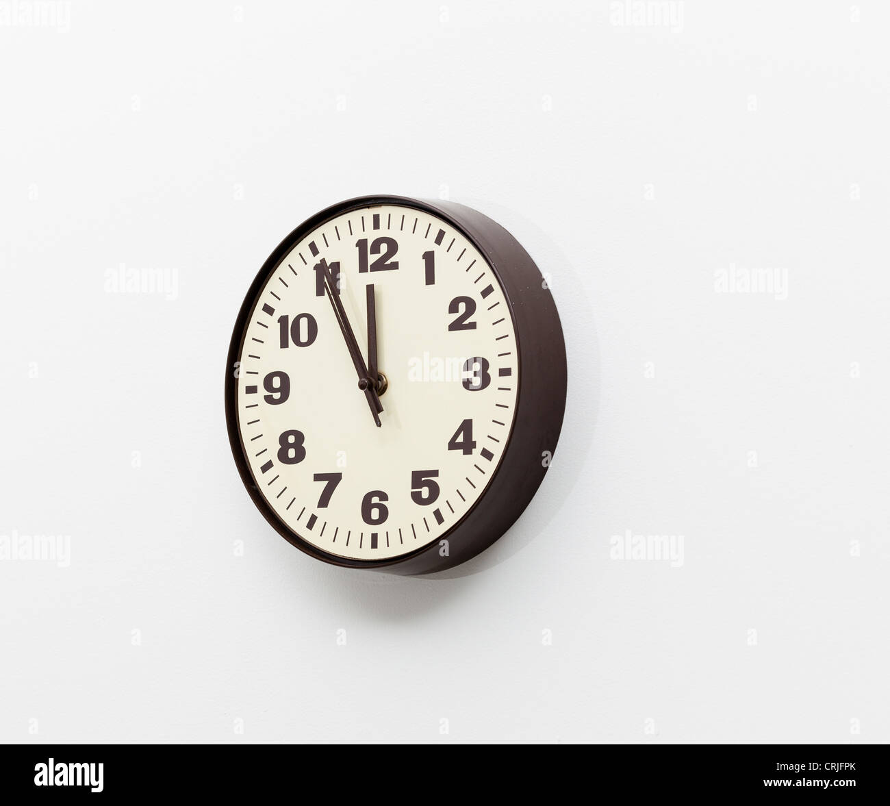 Orologio da parete che mostra cinque minuti alle ore 12 Foto Stock