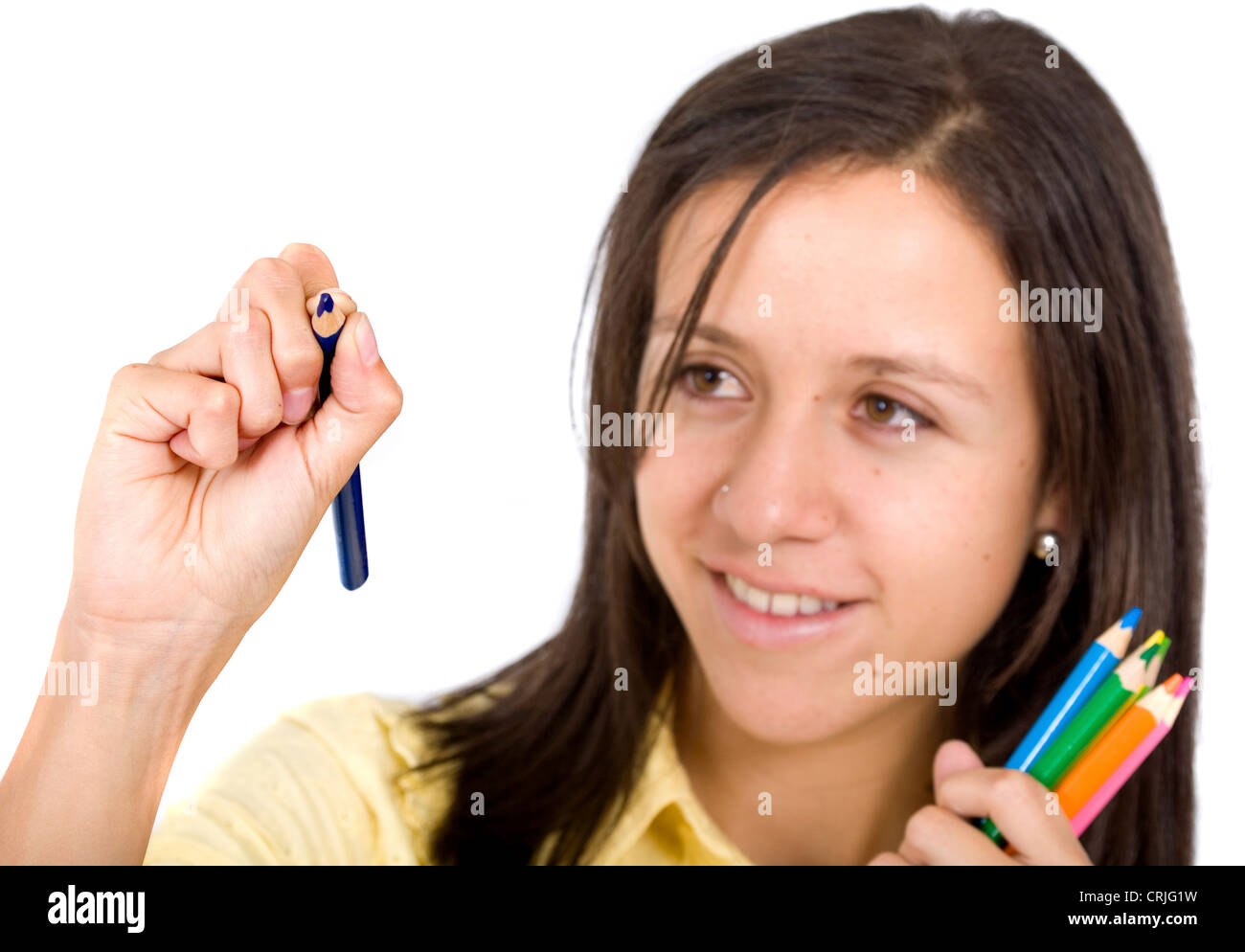 Giovane donna con una mano piena di colorati disegno pecils qualcosa su un immaginario vetro nella parte anteriore della sua Foto Stock