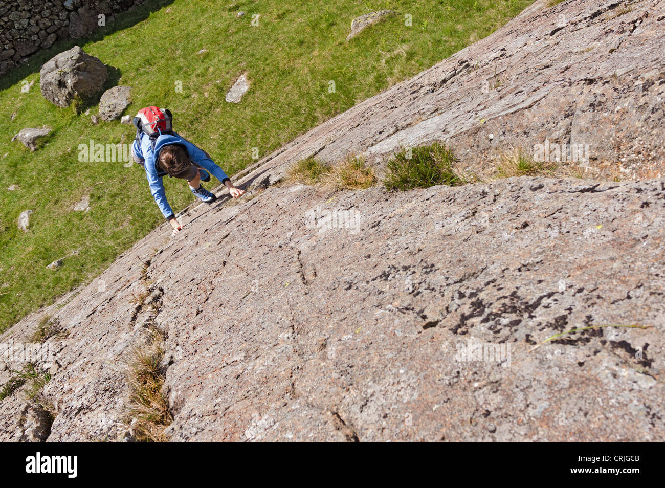 Female Rock scrambler salendo Seathwaite lastre, Lake District, UK. Foto Stock