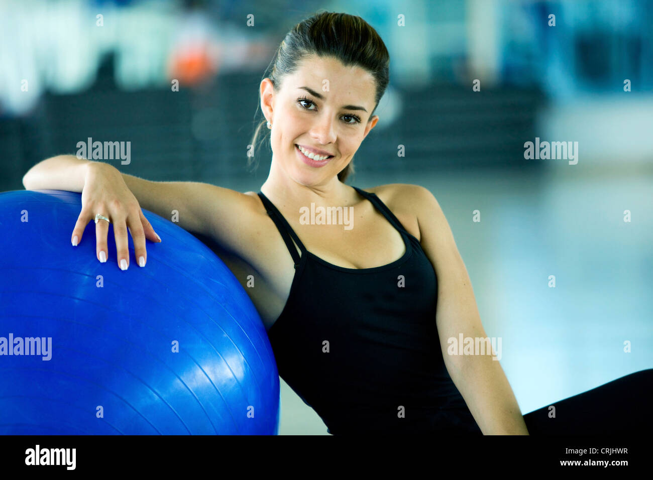 Palestra donna facendo pilates esercizi su una sfera blu Foto Stock