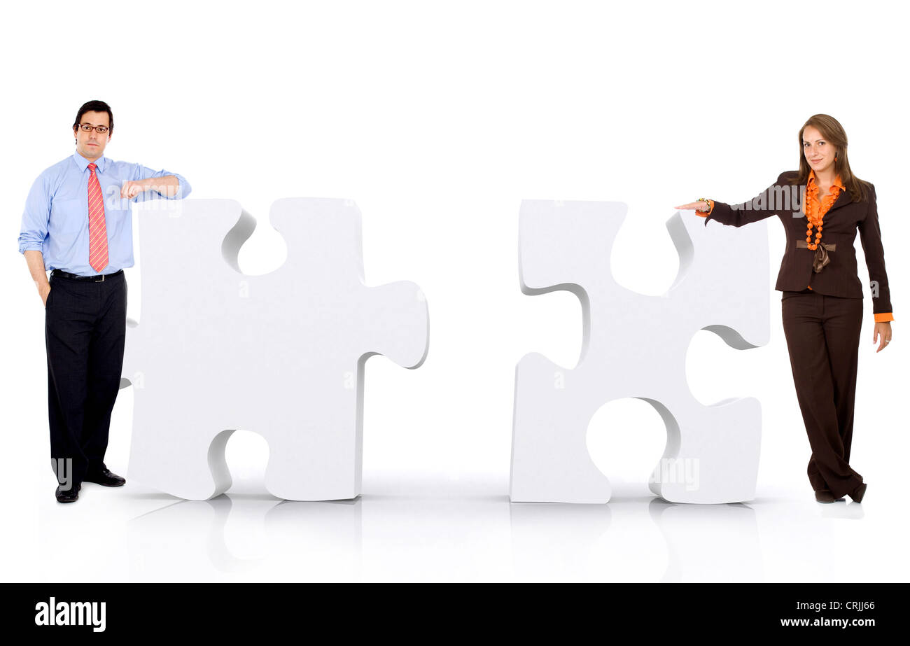 Young business persone appoggiata contro il gigantesco puzzle di pezzi Foto Stock