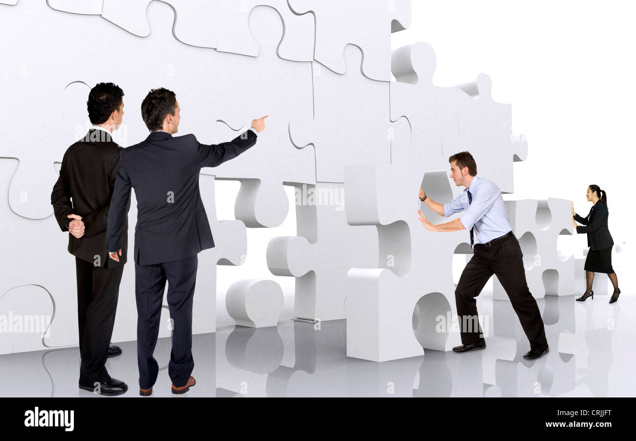 Young business Team building una parete gigante di pezzi di un puzzle Foto Stock