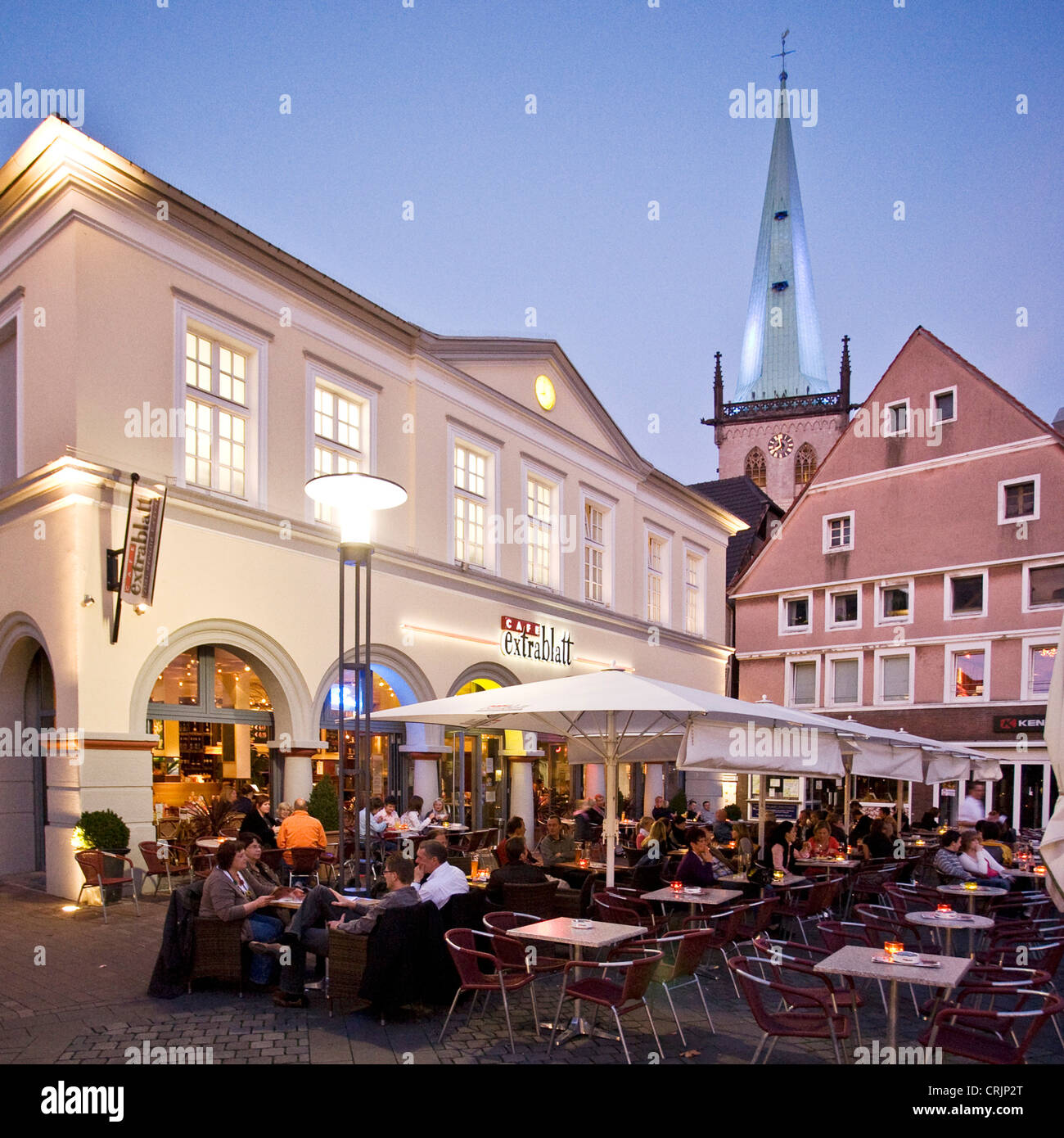 Persone siiting in un ristorante di strada sul mercato di Unna al blue ora, la torre illuminata chiesa Stadtkirche, in background, in Germania, in Renania settentrionale-Vestfalia, la zona della Ruhr, Unna Foto Stock