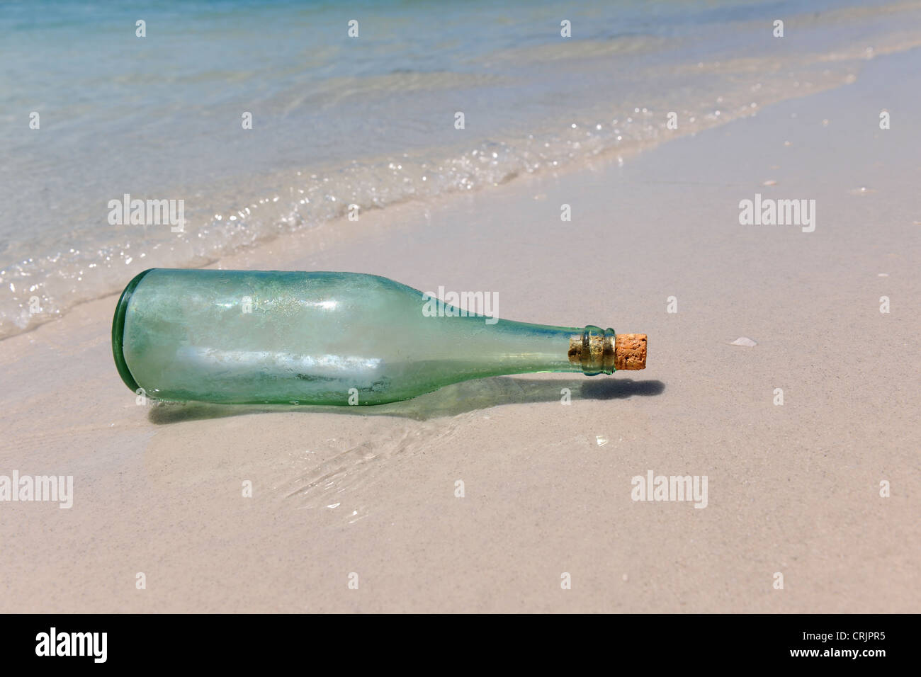Un messaggio in bottiglia appoggiata sulla riva della spiaggia Foto Stock