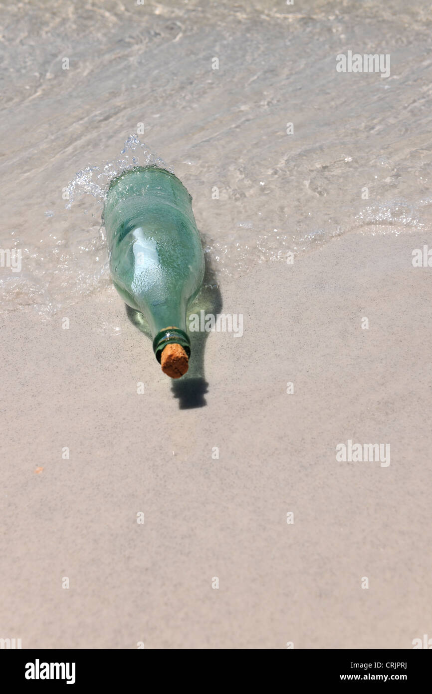 Un messaggio in bottiglia sulla riva sabbiosa Foto Stock