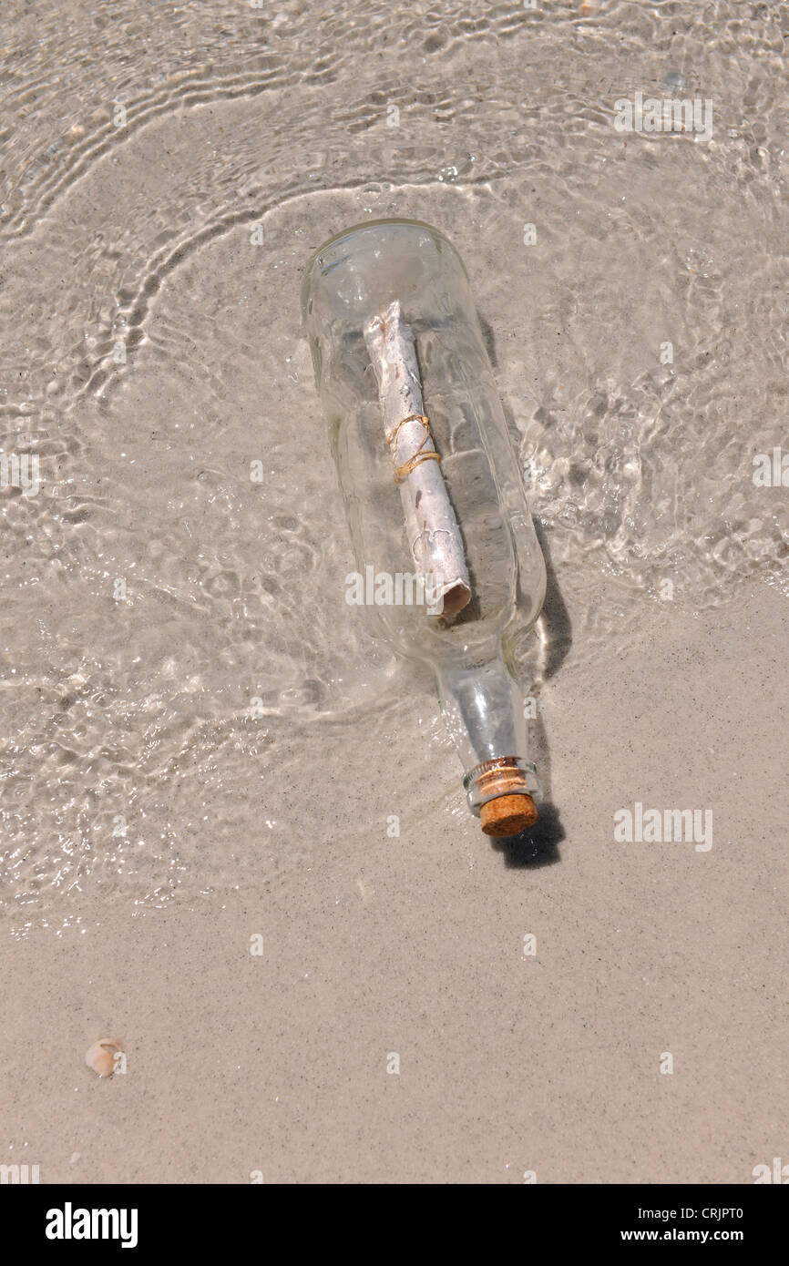 Un messaggio in bottiglia lavata dalla spiaggia sabbiosa Foto Stock